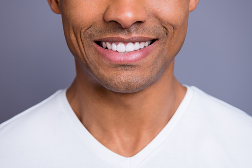 Close up of man with perfect teeth in front of purple background