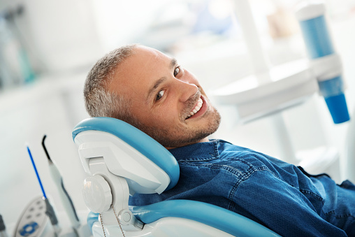 Patient laying back in dental chair smiling