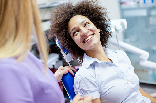 Smiling patient in dental chair looking up at doctor