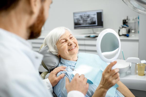 Elderly woman enjoying her new implant supported denture at Glen Perio in Glenview, IL