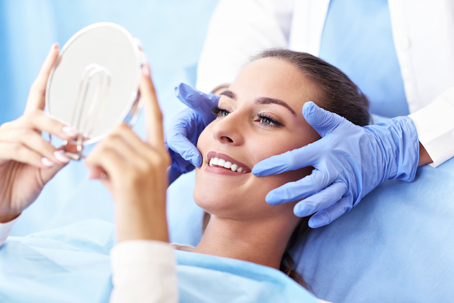 Woman smiling with handheld mirror at Glen Perio in Glenview, IL